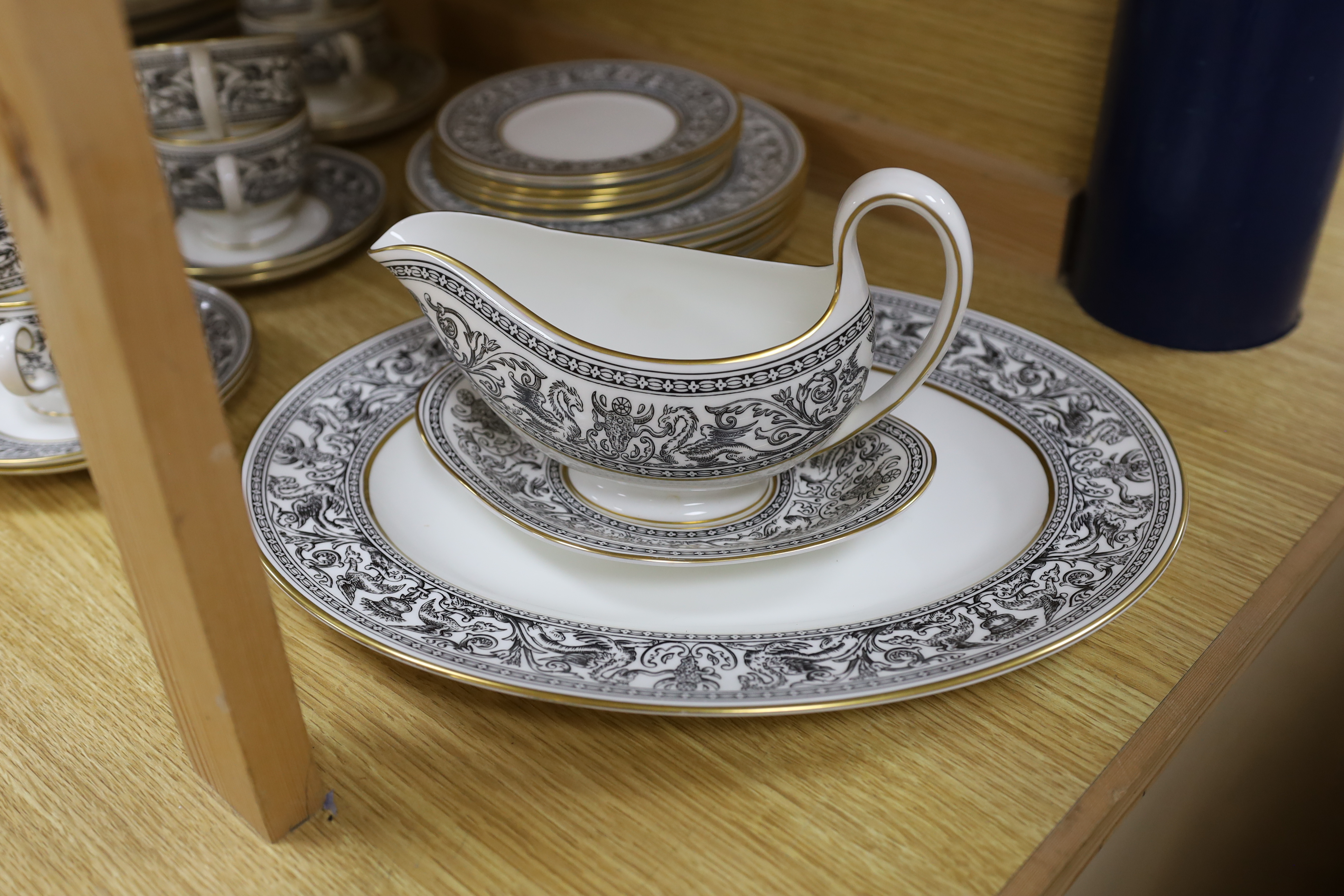 A Wedgwood Florentine part dinner set including twin handled cups, oval platter and dinner plates, largest 34cm wide